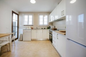 A modern kitchen with white cabinets, a dishwasher, an oven, and a refrigerator. - Villa in Lanzarote | Pool | Private Garden (Yaiza)