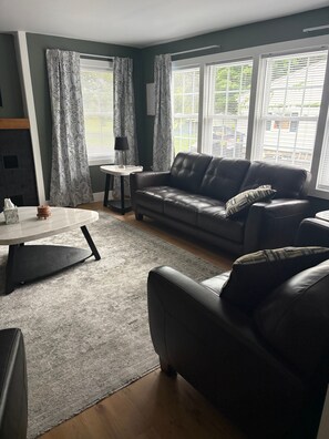 A living room with a sofa, a coffee table, and a rug. - 3 bedroom home outside auburn (Auburn)