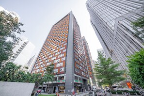 Un edificio de gran altura con un diseño arquitectónico moderno, que combina fachadas de vidrio y metal.