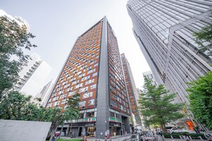 A high-rise building with a modern architectural design, featuring a mix of glass and metal facades.