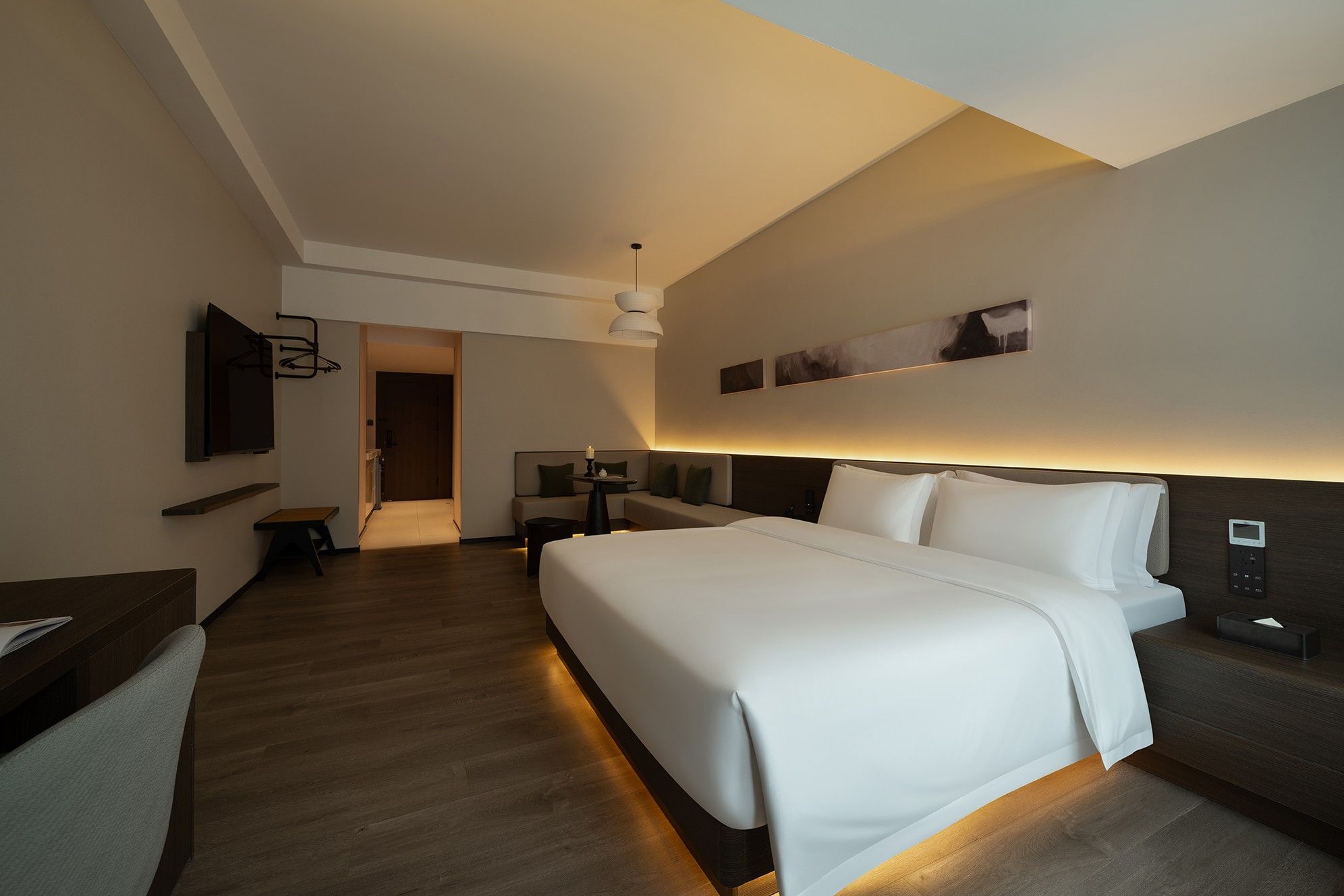 Una habitación de hotel moderna con una cama grande, mesitas de noche, un televisor y un escritorio.