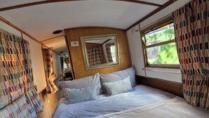 Un dormitorio con una cama grande, un espejo y una ventana.