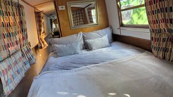 Ein Schlafzimmer mit einem großen Bett, einem Spiegel und einem Fenster.