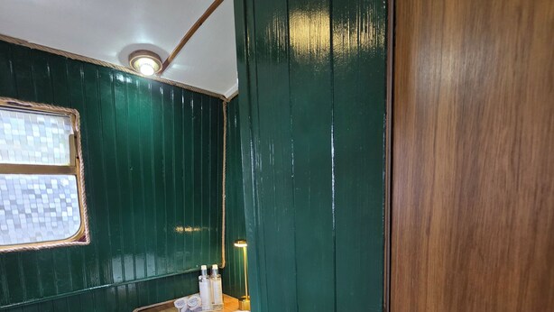 Un baño pequeño con tocador de madera, lavamanos blanco y retrete.