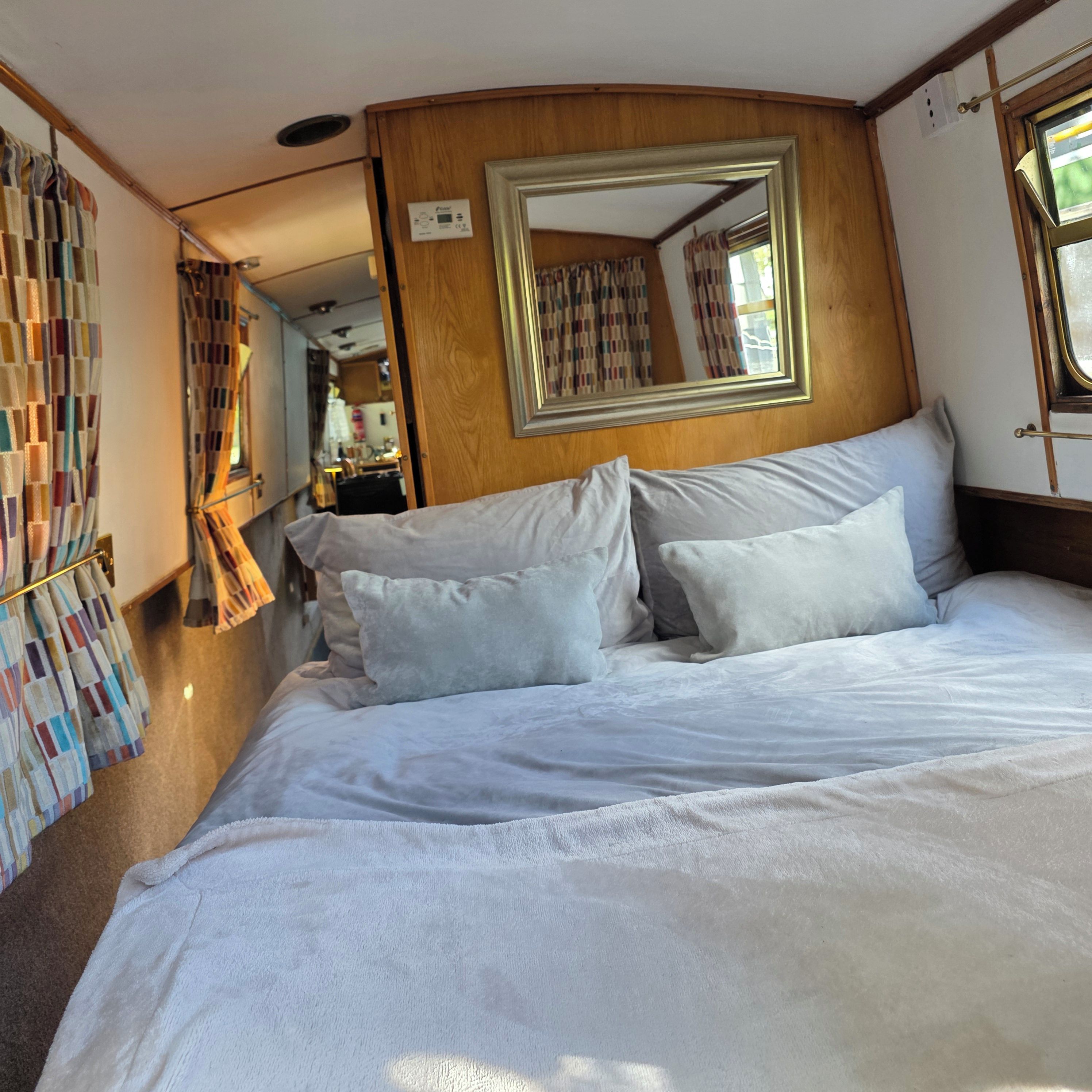 A room with a bed, a mirror, and a window.