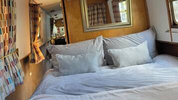 A room with a bed, a mirror, and a window.