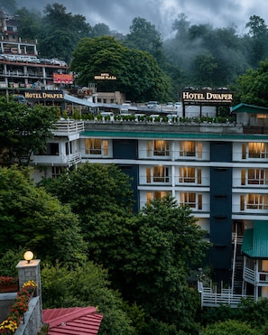 Ein mehrstöckiges Hotel mit Balkonen und Blick auf die umliegende Grünfläche.