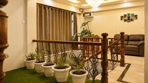 A staircase with wooden balusters, a chandelier, and potted plants. - Hotel Dwaper by Aventra Retreat  (Mussoorie)