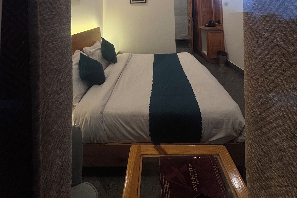 Ein Hotelzimmer mit einem Bett, einem Deckenventilator und einem gerahmten Bild an der Wand.