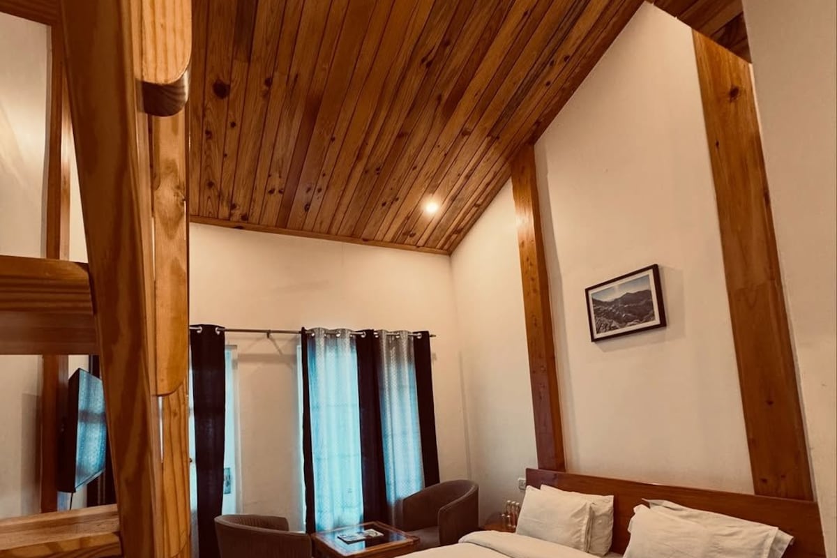 Ein Schlafzimmer mit Holzwänden, einem Bett, einem Schreibtisch und einem Stuhl.