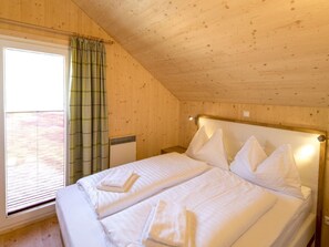 A room with a wooden ceiling, a bed with white linens, a window with blinds, and a curtain. - Cabin With 1 Bedroom (Sankt Georgen am Kreischberg)