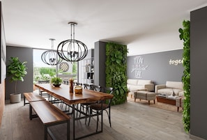 Un espacio habitable moderno con comedor, un juego de sofá y una pared con una cita motivacional.