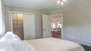 A bedroom with a bed, a closet, and a kitchenette area. - EZ Carriage House by Lake Monroe (Bloomington)