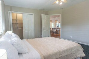 Un dormitorio con cama, armario y una pequeña cocina.