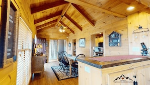 A wooden cabin interior with a dining area, kitchen, and a visible staircase. - Sugardaddy's Cabin With Views And Fireplace (Sugar Mountain)