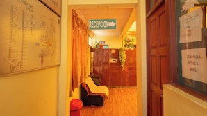 A hotel reception area with a reception desk, a sign indicating the direction to the reception, and a map on the wall. - Alojamiento la Gran Estacion (Uyuni)
