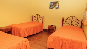 A room with two single beds, a small bedside table, and a wall-mounted picture. - Alojamiento la Gran Estacion (Uyuni)