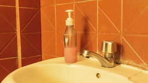 A bathroom sink with a soap dispenser and faucet. - Alojamiento la Gran Estacion (Uyuni)