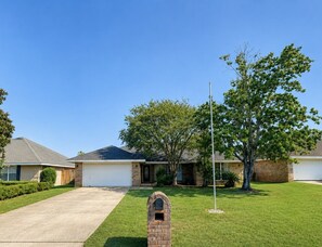 A residential property with a garage, a lawn, and a brick mailbox. - Crane Cove Hideaway, New Listing, Minutes to the Beach (Gulf Breeze)
