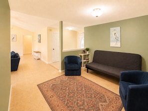 A living room with a sofa, armchairs, a patterned rug, and a painting on the wall. - Crane Cove Hideaway, New Listing, Minutes to the Beach (Gulf Breeze)