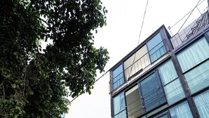 Un immeuble à plusieurs étages, doté de grandes fenêtres et d’une façade blanche.