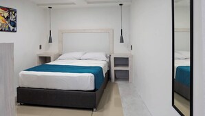 Une chambre à coucher moderne avec un lit, des tables de chevet, un miroir et un tableau au mur.