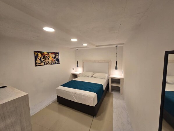 Quarto moderno com cama, mesas de cabeceira, um quadro e um espelho.