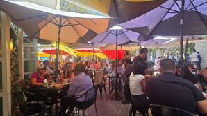 Un espace extérieur aménagé pour les repas, avec des tables et des chaises, protégé par des parasols.