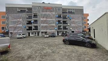 A multi-story building with a parking area in front.