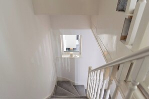 A staircase with a handrail and a window at the top. - Blue Becontree at Goresbrook London (Dagenham)