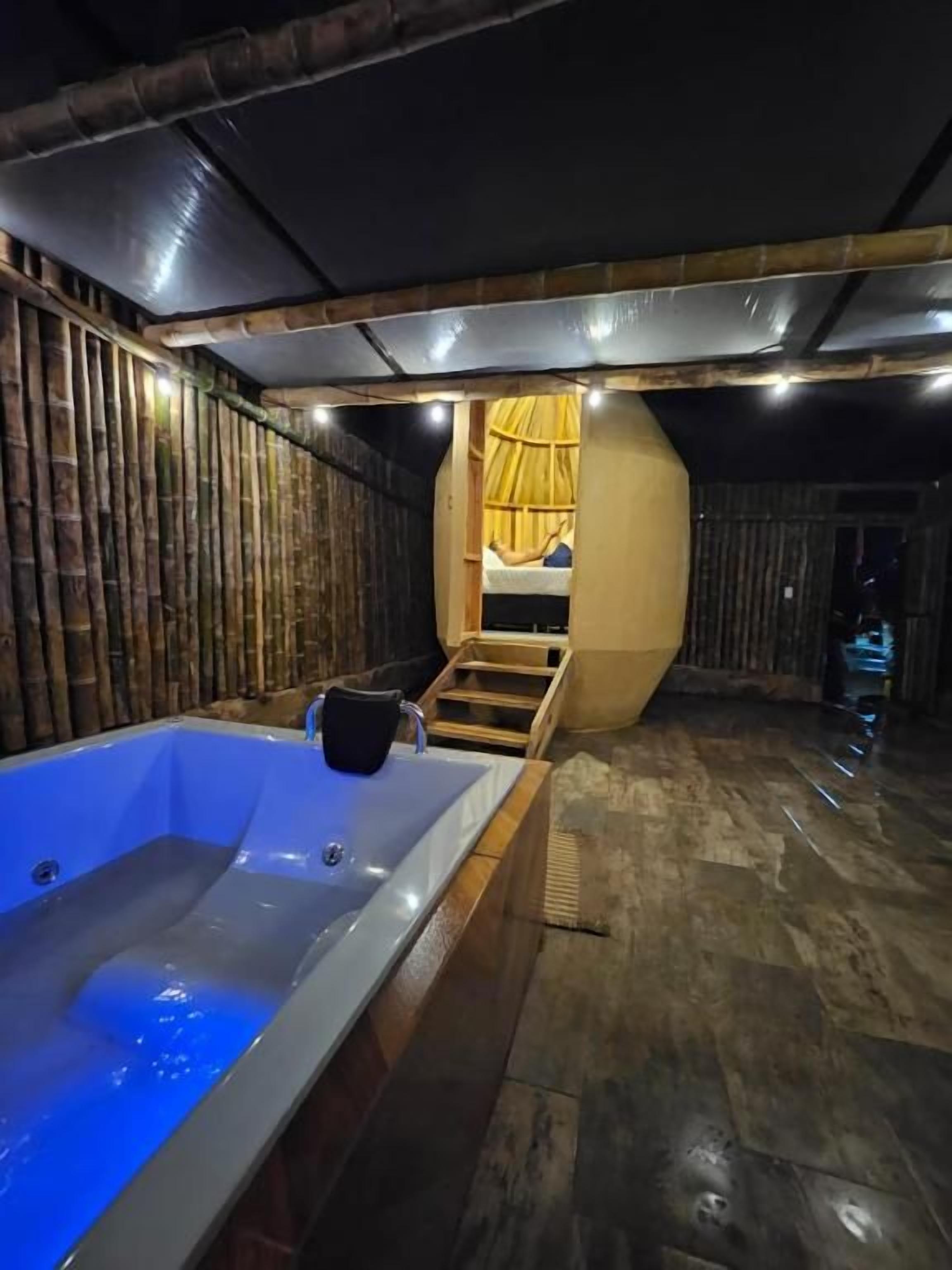 A spa room with a large bathtub, wooden walls, and a curved ceiling.