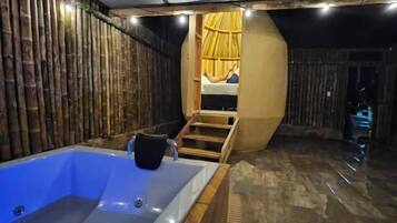 A spa room with a large bathtub, wooden walls, and a curved ceiling.