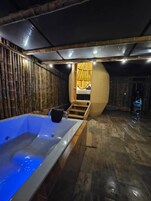 Un cuarto de spa con una bañera grande, paredes de madera y techo curvo.