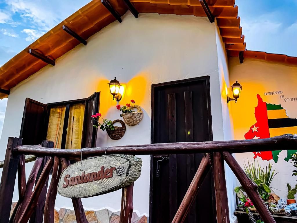 A building with a rustic facade, a wooden sign reading 'Santander,' and a wall-mounted map.