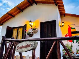 Un edificio con fachada rústica, un cartel de madera con el nombre 'Santander' y un mapa colgado en la pared.