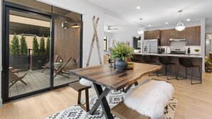 Une cuisine moderne avec des meubles en bois, un îlot central et des tabourets de bar.