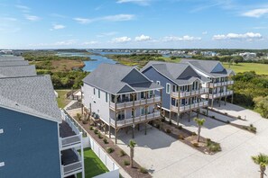 A beachfront property with multiple-story buildings featuring balconies and a view of the water. - Water views with pool and hot tub (North Topsail Beach)