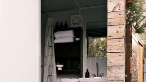 Une petite salle de bain comprenant des toilettes, un lavabo et un rideau de douche.
