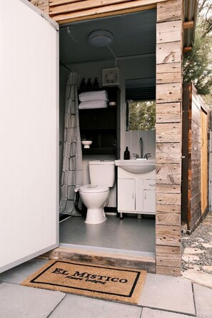 Un baño pequeño con inodoro, lavamanos y cortina de ducha.
