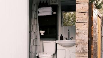 Ein kleines Badezimmer mit Toilette, Waschbecken und Duschvorhang.