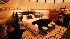 Une chambre confortable avec un lit, des lampes de chevet, un tapis et une armoire en bois.