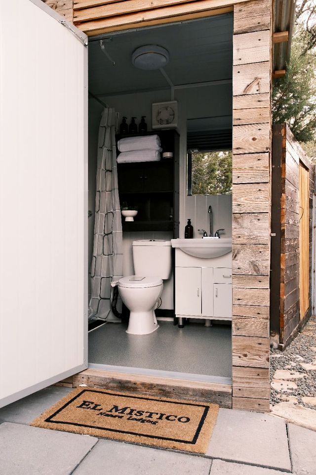 Een kleine badkamer met toilet, wastafel en douchegordijn.