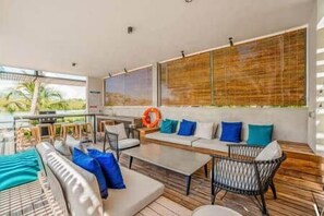 A modern interior with a seating area, a dining table, and a view of the outdoors. - Luxury Penthouse with Private Pool (Grande Riviere Noire)