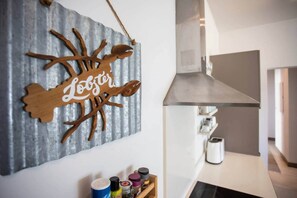 Eine Küche mit einer Holzwanddekoration, einer Edelstahl-Dunstabzugshaube und einer Arbeitsplatte mit verschiedenen Gegenständen.
