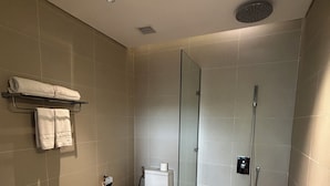 Een moderne badkamer met een douchekabinet, een toilet en een handdoekrek.