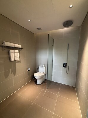 A modern bathroom with a glass-enclosed shower, a toilet, and a towel rack. - Blue Sea & Sand Cat Ba Resort (Cat Ba Island)