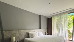 Een moderne slaapkamer met een groot bed, een nachtkastje en een raam met gordijnen.
