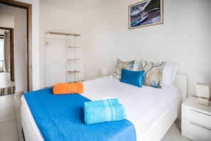 A hotel room with a bed, a nightstand, a bedside table, a wardrobe, and a painting on the wall. - Stylish Central Three Bed Duplex with Private Pool (Flic en Flac)