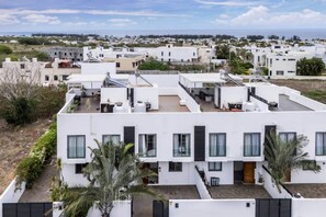 A modern residential building with multiple balconies, large windows, and a flat roof. - Stylish Central Three Bed Duplex with Private Pool (Flic en Flac)