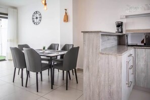 A modern kitchen with a marble countertop, a coffee maker, and a clock on the wall. - Stylish Central Three Bed Duplex with Private Pool (Flic en Flac)